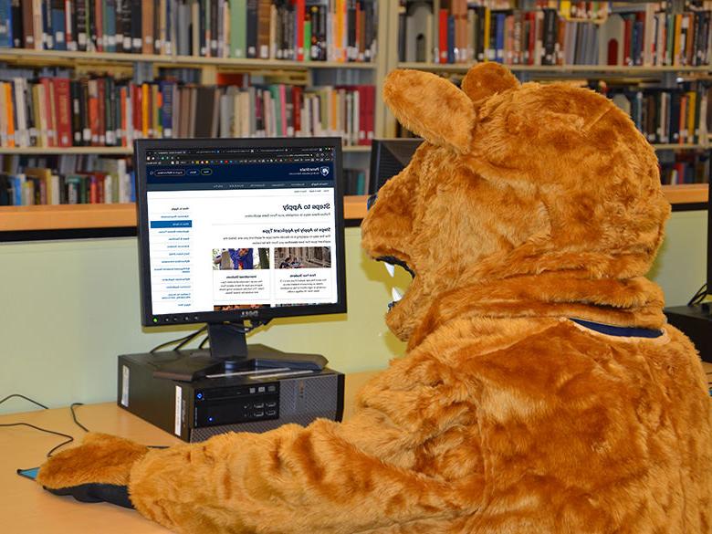 Nittany Lion on a computer applying to college