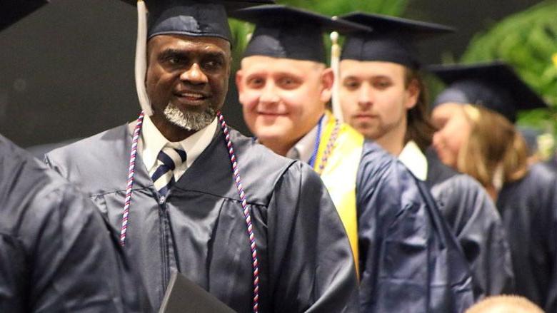 Graduates wearing caps and gowns smiling