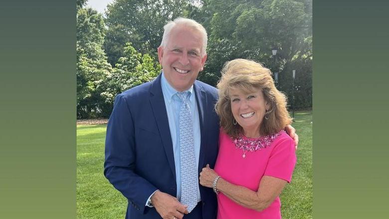 Stephen Pace and Rita Pace, smiling and standing outside in front of some trees